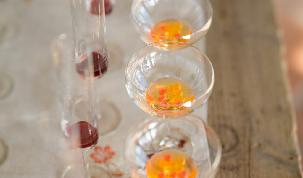 A row of wine glasses lined up on a table for a corporate event catering.
